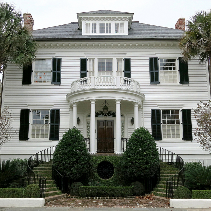 White House with shutters and palm trees warm climate